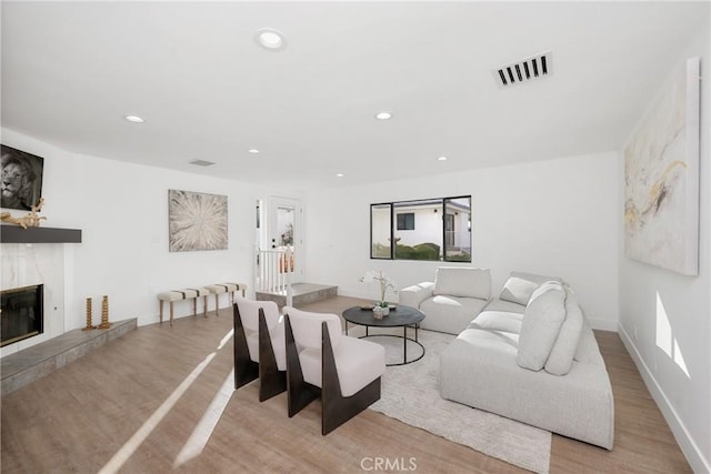 living area featuring recessed lighting, visible vents, a fireplace, and wood finished floors