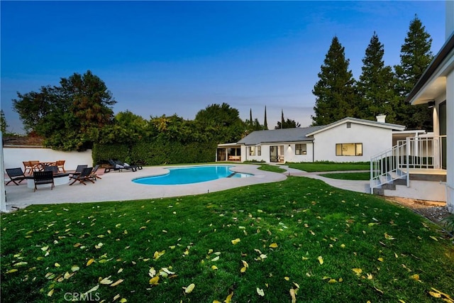 outdoor pool with an outdoor hangout area, a patio, and a yard