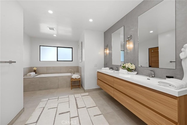 full bath featuring a garden tub, double vanity, a sink, and visible vents