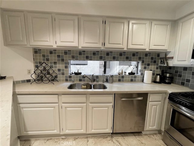 kitchen with a sink, white cabinets, light countertops, appliances with stainless steel finishes, and decorative backsplash