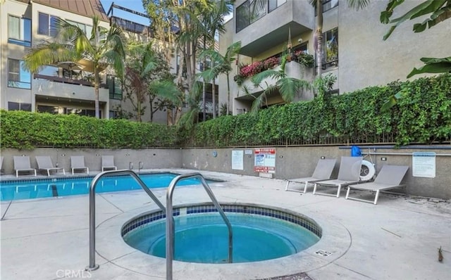 view of swimming pool featuring a hot tub