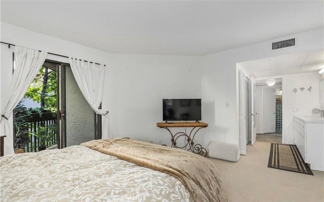 bedroom with access to outside, visible vents, a sink, and light carpet