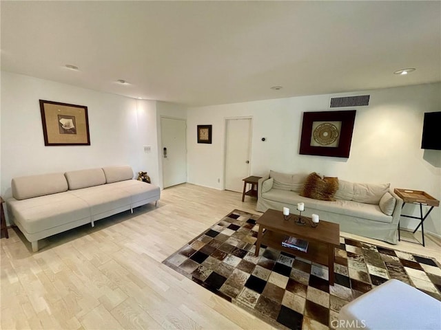 living room with recessed lighting, visible vents, and light wood-style floors