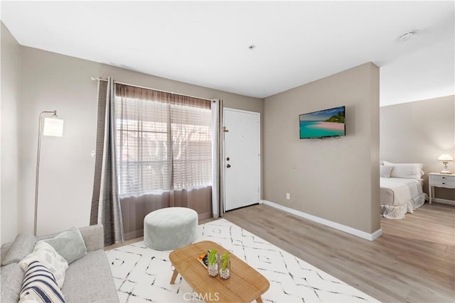 living area with light wood-style flooring and baseboards