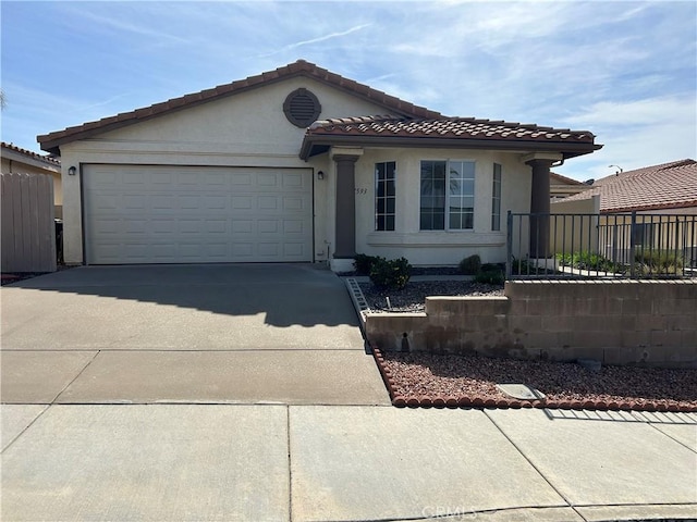 view of front of home with a garage, concrete driveway, fence, and stucco siding