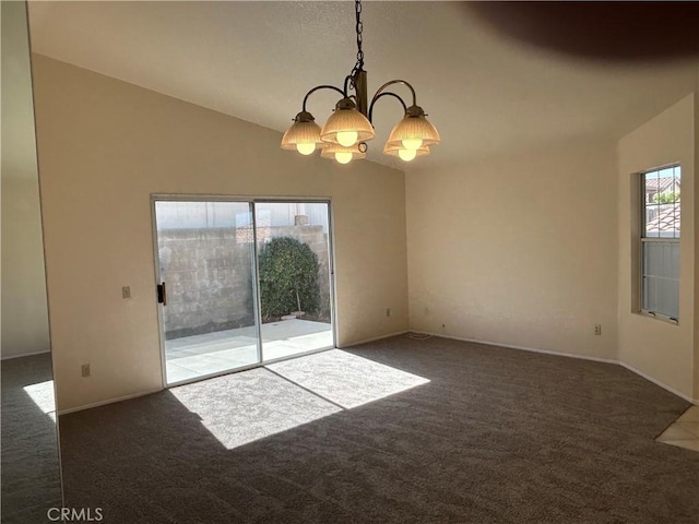spare room featuring dark carpet, vaulted ceiling, and a notable chandelier