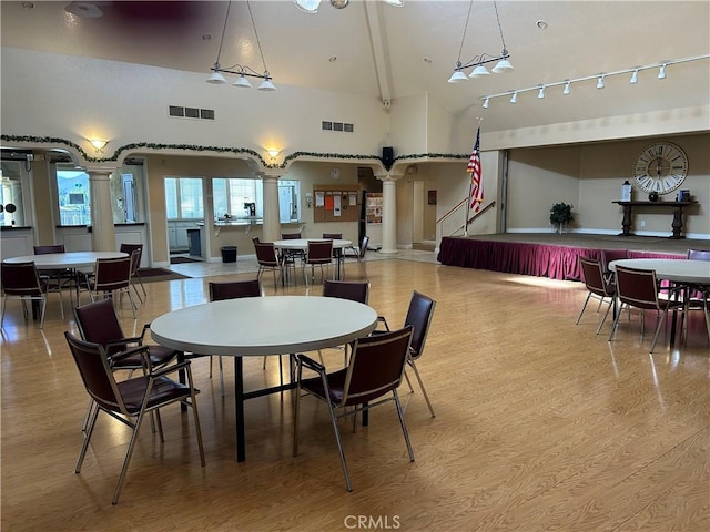 dining room featuring ornate columns, light wood-style flooring, and visible vents