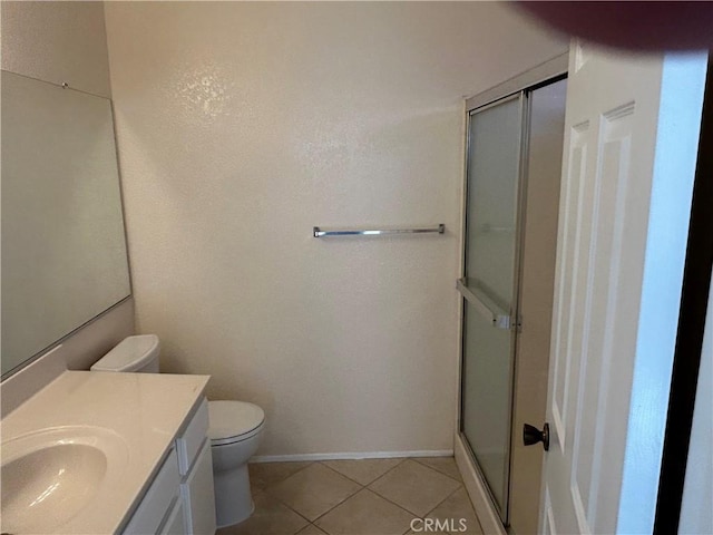 bathroom featuring tile patterned flooring, toilet, a shower stall, and vanity