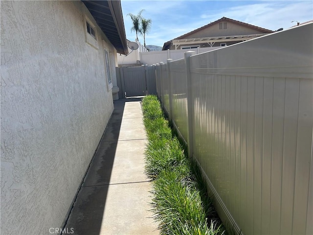 view of side of property with fence and stucco siding