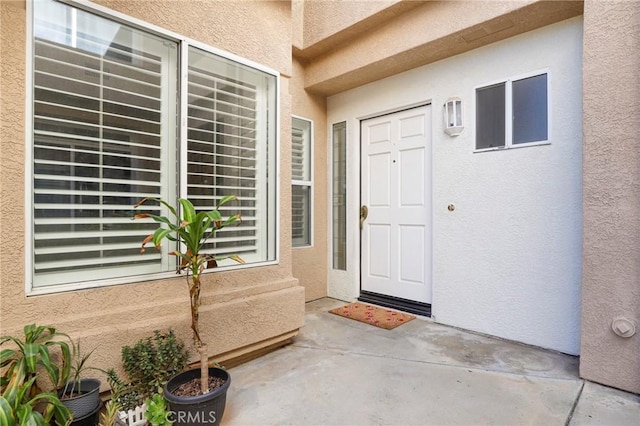 property entrance with a patio area and stucco siding