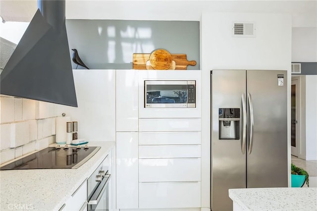 kitchen with stainless steel appliances, exhaust hood, visible vents, and decorative backsplash