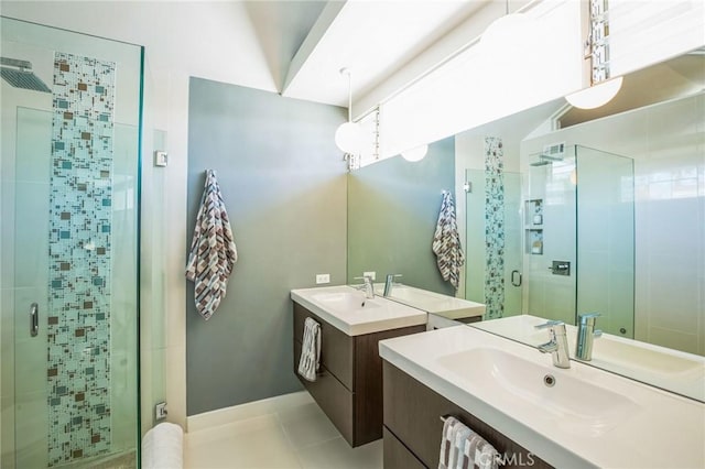 bathroom featuring two vanities, a stall shower, tile patterned flooring, and a sink