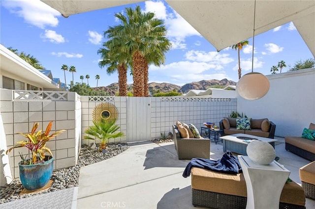 view of patio / terrace featuring a mountain view, a fenced backyard, and an outdoor living space