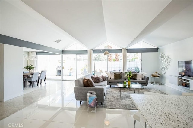 living area featuring lofted ceiling, plenty of natural light, and visible vents