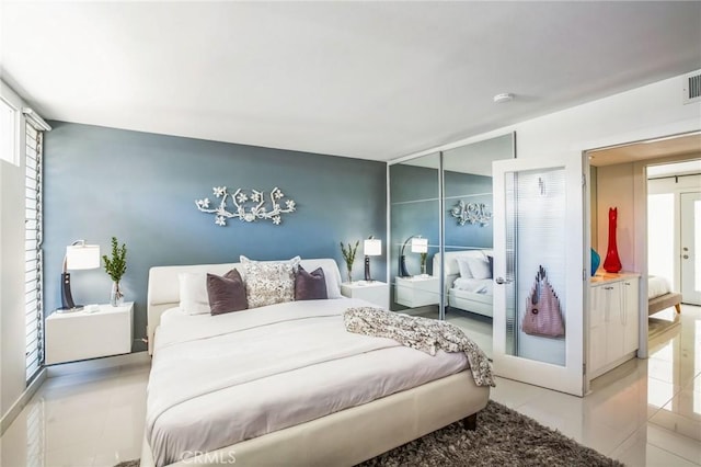 bedroom featuring light tile patterned floors, visible vents, a closet, and french doors