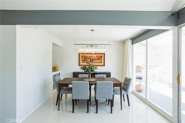 dining space with baseboards, a chandelier, and a wealth of natural light