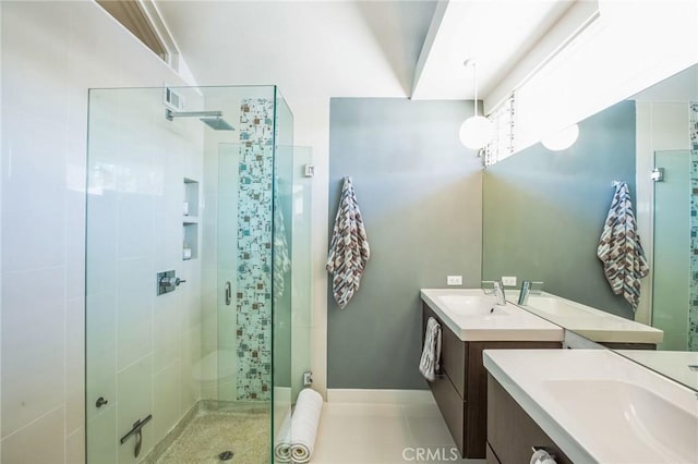 full bath featuring a stall shower, tile patterned flooring, two vanities, and a sink