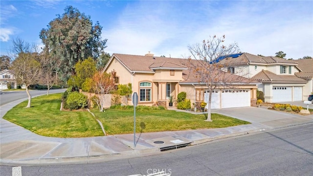 mediterranean / spanish-style house featuring a front yard, concrete driveway, and stucco siding