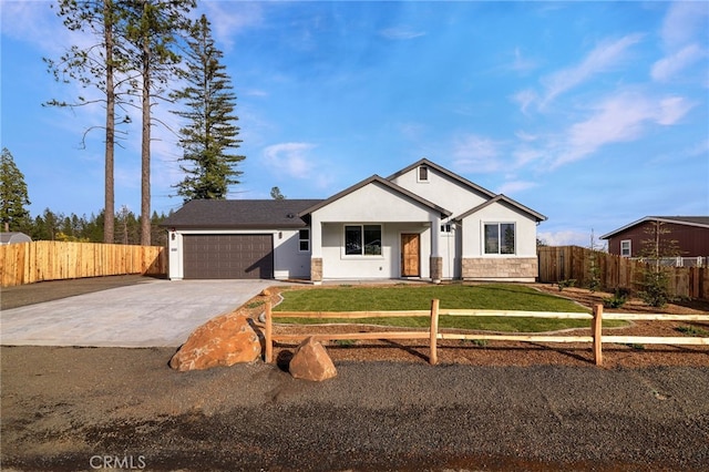 view of front of house featuring stucco siding, an attached garage, fence, driveway, and a front lawn