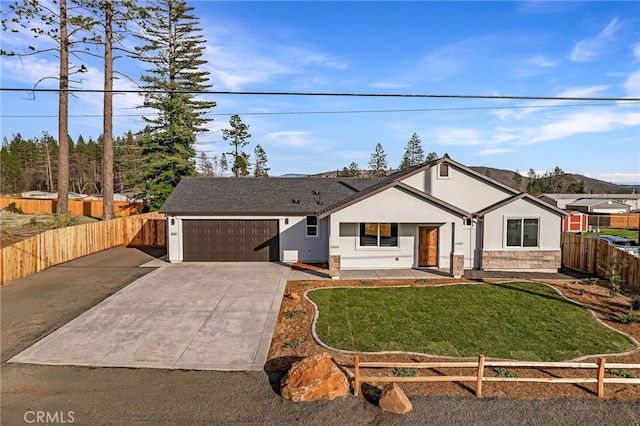 view of front of home featuring concrete driveway, an attached garage, fence, a front yard, and stucco siding