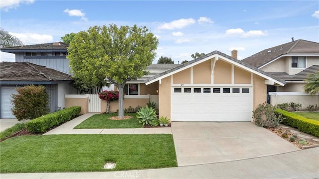 view of front of home featuring stucco siding, fence, a garage, driveway, and a front lawn