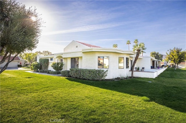 view of front of home with a front lawn and stucco siding