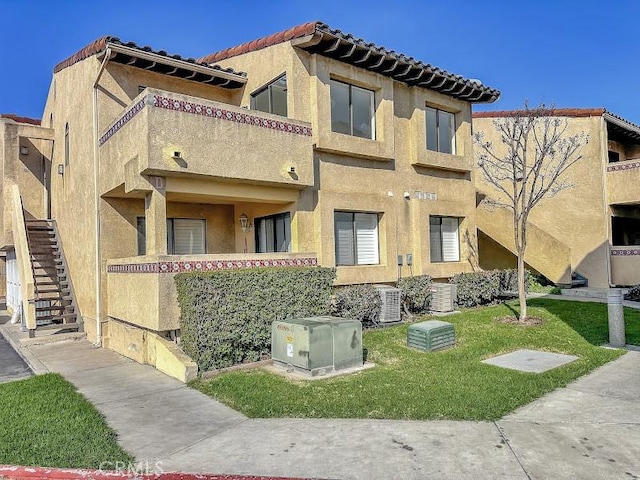 view of property featuring central AC unit and stairs