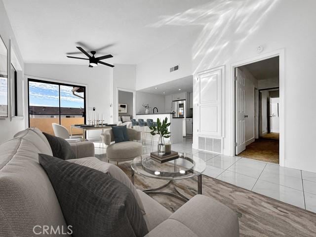 living area with visible vents, high vaulted ceiling, light tile patterned floors, and a ceiling fan