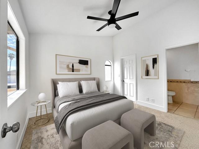 tiled bedroom with connected bathroom, carpet, ceiling fan, baseboards, and lofted ceiling