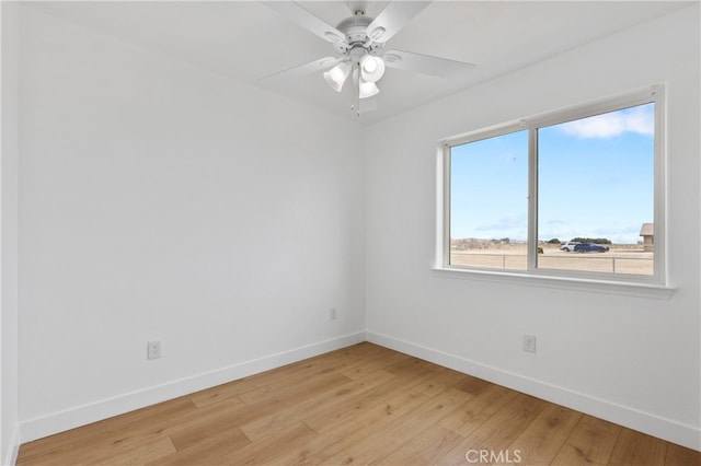 empty room with light wood-style floors, baseboards, and a ceiling fan