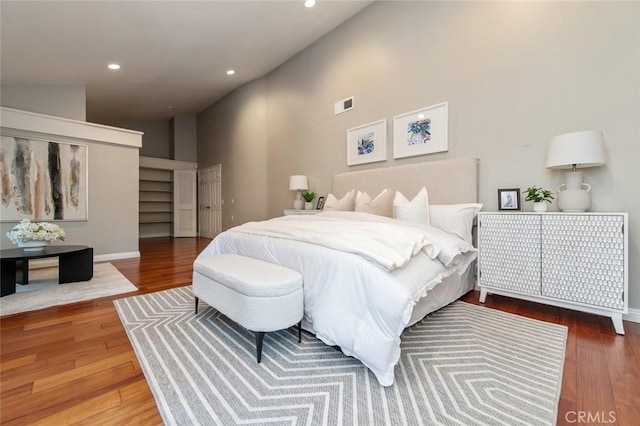 bedroom featuring high vaulted ceiling, wood finished floors, visible vents, and recessed lighting