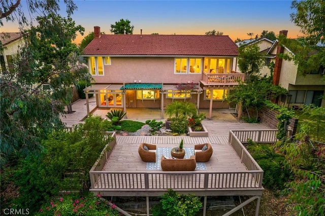 back of house with outdoor dining area, a patio, stucco siding, a deck, and a tiled roof