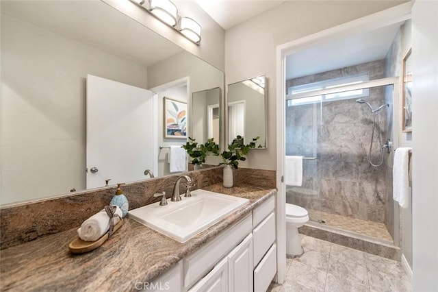 bathroom with toilet, a stall shower, and vanity