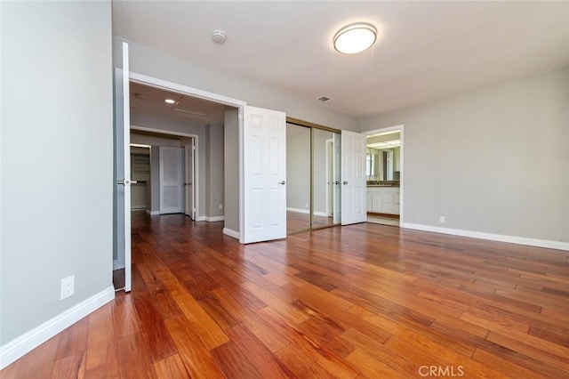 unfurnished bedroom with wood finished floors and baseboards