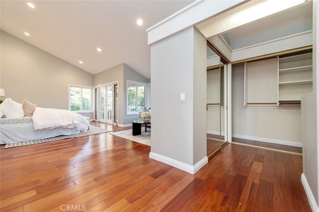 unfurnished bedroom with lofted ceiling, recessed lighting, wood finished floors, and baseboards