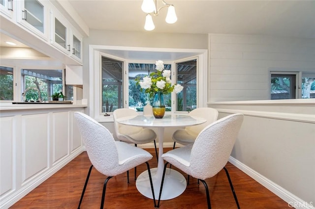 dining space with a chandelier, dark wood-style flooring, and baseboards