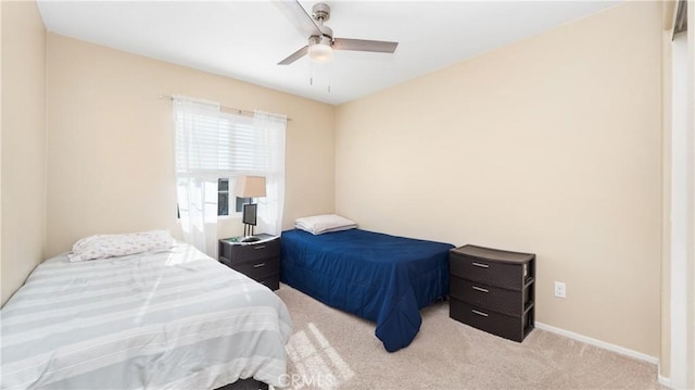 bedroom with light carpet, ceiling fan, and baseboards