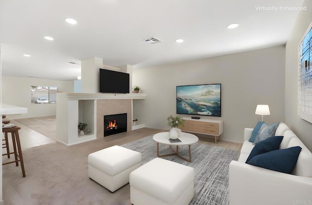 living area featuring light carpet, visible vents, a tiled fireplace, and recessed lighting