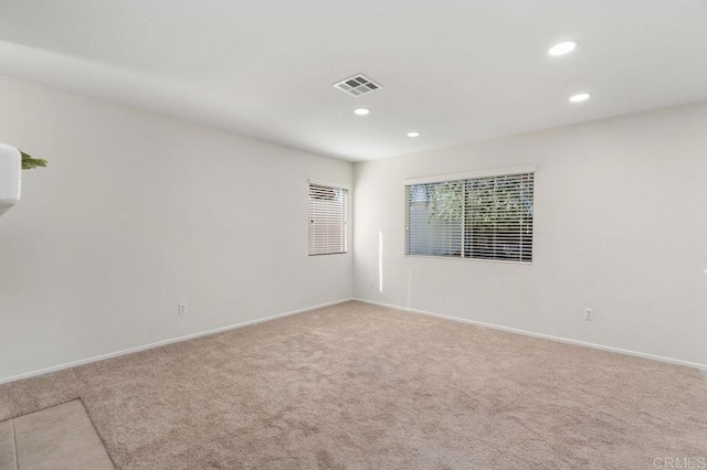 spare room with carpet, visible vents, baseboards, and recessed lighting