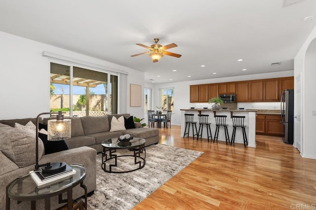 living area featuring ceiling fan, visible vents, light wood-style flooring, and recessed lighting