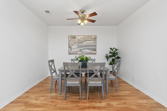 dining area with light wood-style flooring, baseboards, and ceiling fan