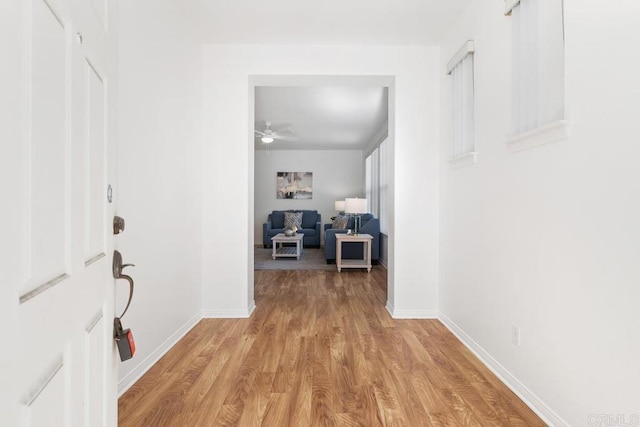 hallway featuring light wood-type flooring and baseboards