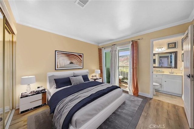 bedroom featuring light wood-style flooring, a sink, visible vents, and crown molding