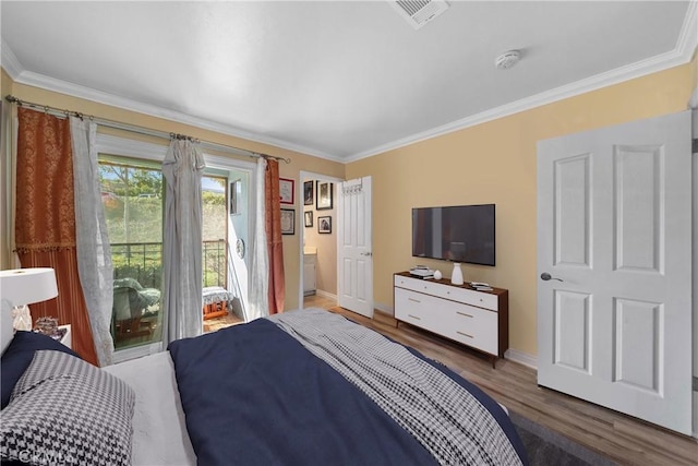 bedroom featuring baseboards, crown molding, visible vents, and wood finished floors