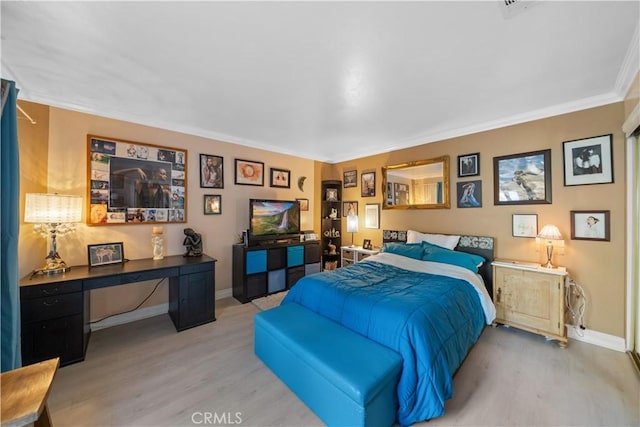 bedroom featuring ornamental molding, baseboards, and light wood finished floors