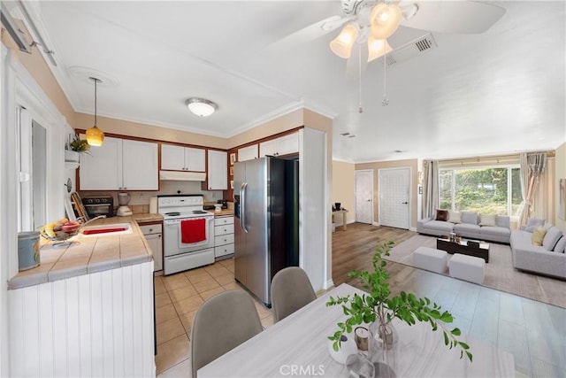 kitchen with electric range, white cabinets, stainless steel fridge with ice dispenser, open floor plan, and decorative light fixtures