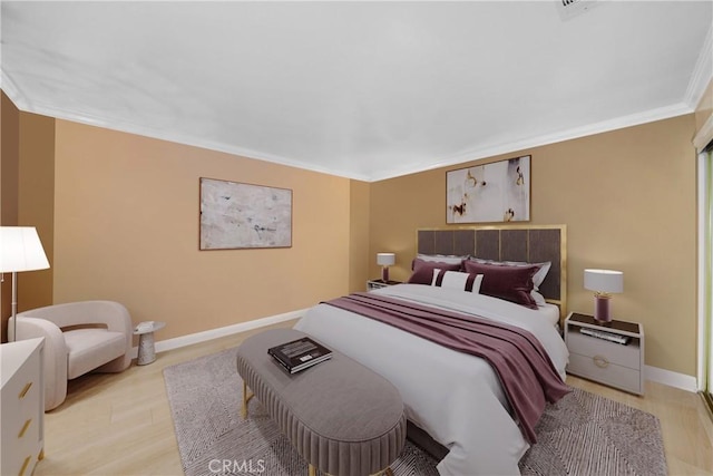 bedroom featuring crown molding, light wood finished floors, and baseboards