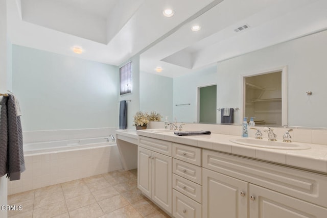 full bathroom featuring a raised ceiling, a sink, a bath, and double vanity