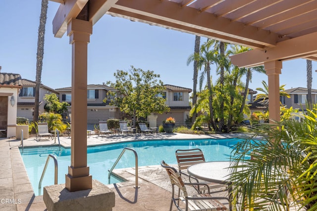 community pool with a residential view, a patio, fence, and a pergola