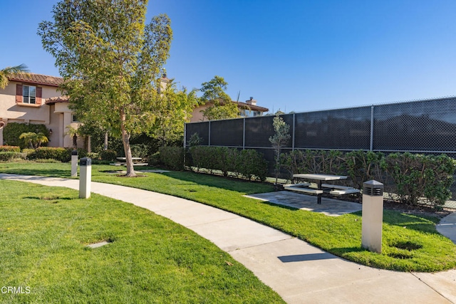 view of community featuring fence and a lawn